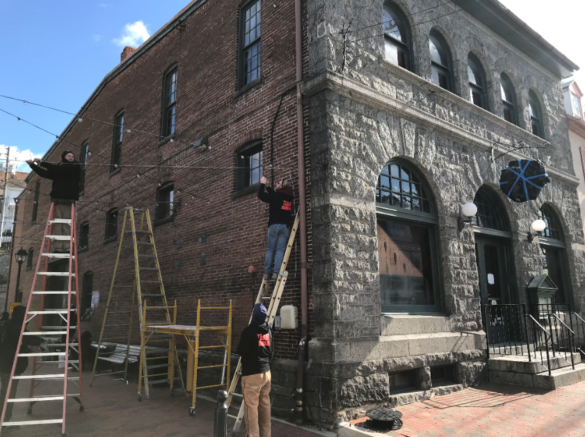 string lighting installation on side of brick building 